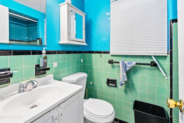 bathroom featuring tile walls, vanity, and toilet