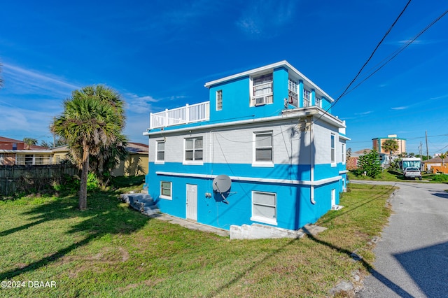 back of house featuring a yard and a balcony