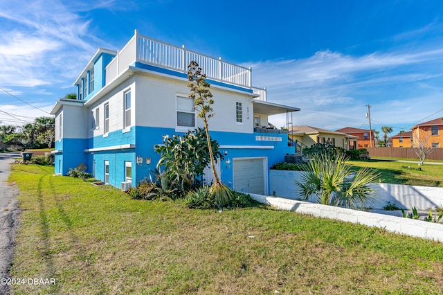 view of home's exterior featuring a garage, a yard, and a balcony