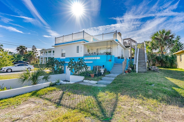 view of front of property with a front lawn and a balcony