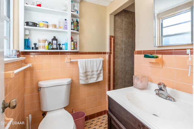 bathroom featuring tile walls, vanity, tile patterned floors, and toilet