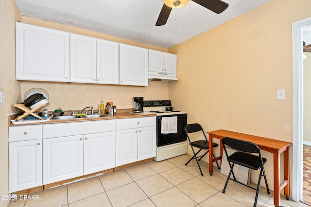 kitchen featuring sink, light tile patterned floors, ceiling fan, electric range, and white cabinetry