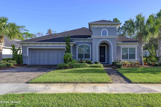 view of front of house with a garage and a front lawn