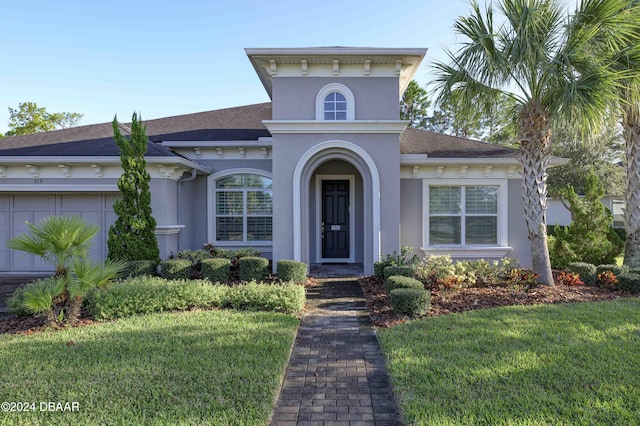 view of front of property with a garage and a front lawn