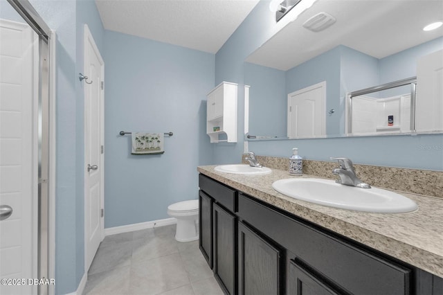 1615 Primo Ct, Holly Hill, FL 32117 - bathroom with double vanity, a shower with door, toilet, tile patterned flooring, and baseboards