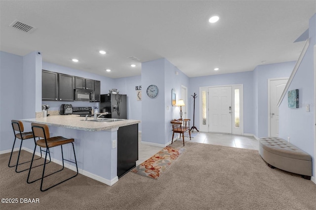 1615 Primo Ct, Holly Hill, FL 32117 - kitchen with black appliances, a kitchen bar, baseboards, light countertops, and a peninsula