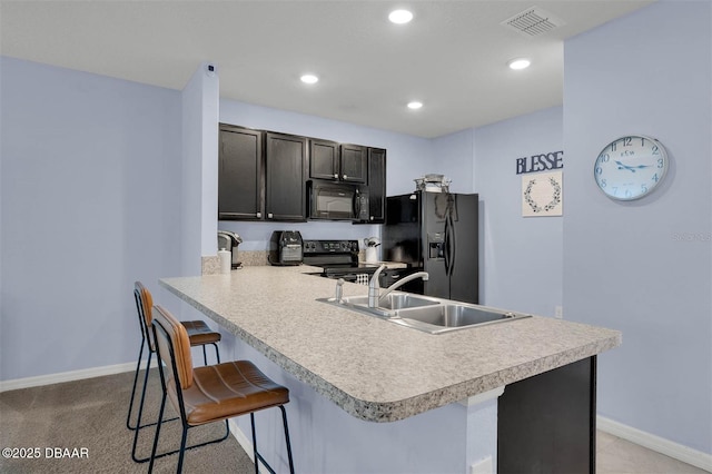 1615 Primo Ct, Holly Hill, FL 32117 - kitchen with black appliances, a sink, a breakfast bar, light countertops, and baseboards