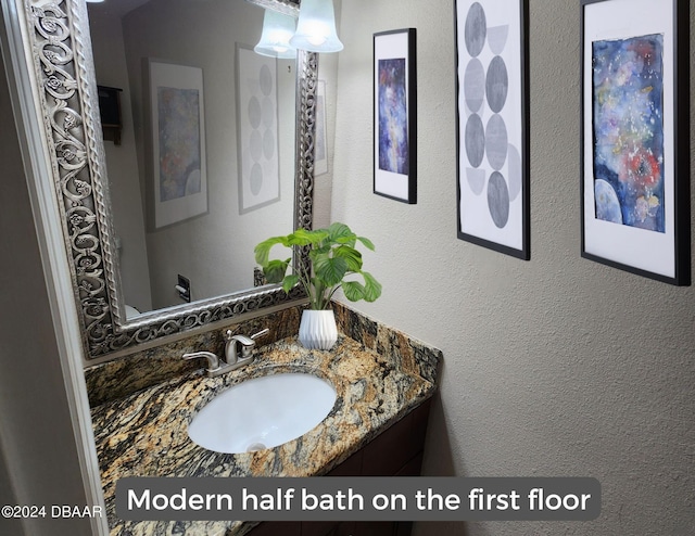 bathroom featuring vanity and a textured wall