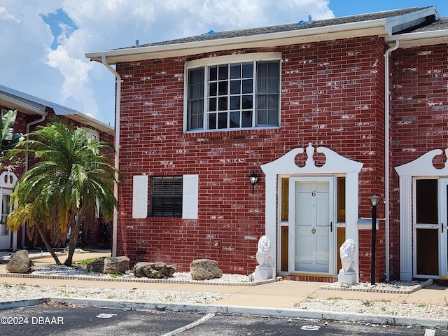 view of front of home featuring uncovered parking and brick siding