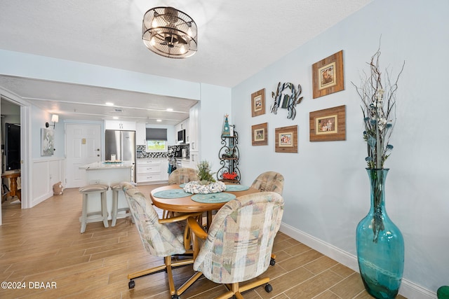 711 N Halifax Ave Unit 405, Daytona Beach, FL 32118 - dining space with a textured ceiling and light hardwood / wood-style flooring