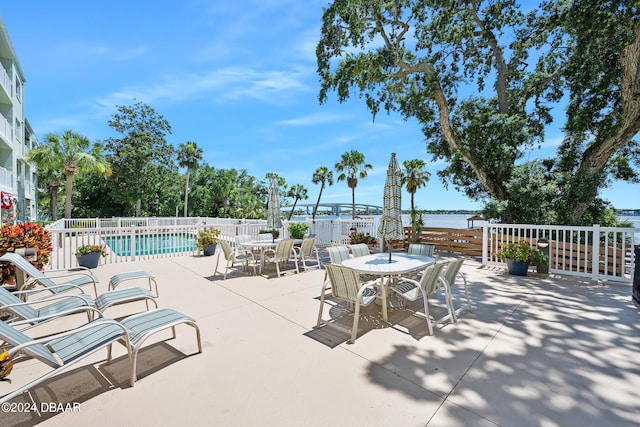 711 N Halifax Ave Unit 405, Daytona Beach, FL 32118 - view of patio featuring a water view and a community pool