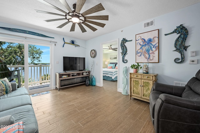 711 N Halifax Ave Unit 405, Daytona Beach, FL 32118 - living room featuring ceiling fan, a textured ceiling, and light wood-type flooring
