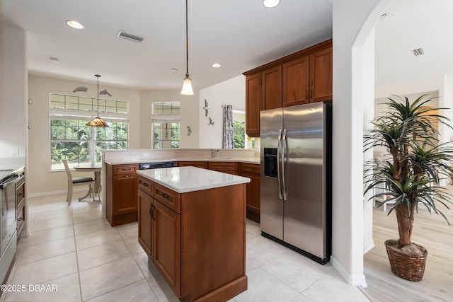1320 Antrim Cir, Ormond Beach, FL 32174 - kitchen featuring a peninsula, visible vents, stainless steel fridge with ice dispenser, brown cabinetry, and light countertops