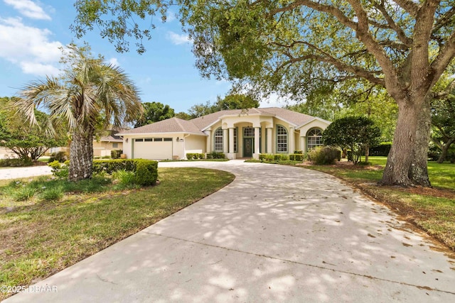 1320 Antrim Cir, Ormond Beach, FL 32174 - view of front of house with stucco siding, a front yard, curved driveway, and a garage