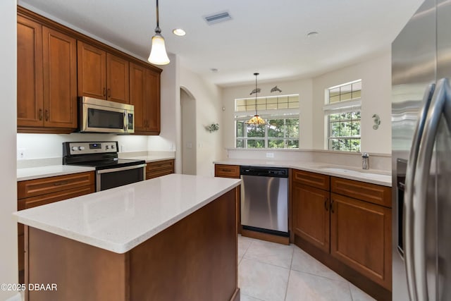 1320 Antrim Cir, Ormond Beach, FL 32174 - kitchen with stainless steel appliances, visible vents, a sink, arched walkways, and brown cabinetry