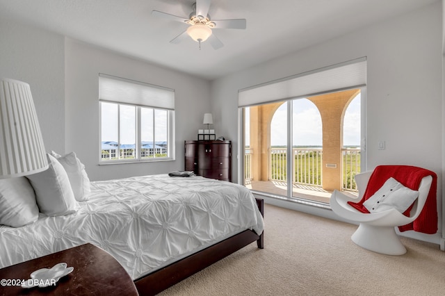 carpeted bedroom with multiple windows, ceiling fan, and access to exterior