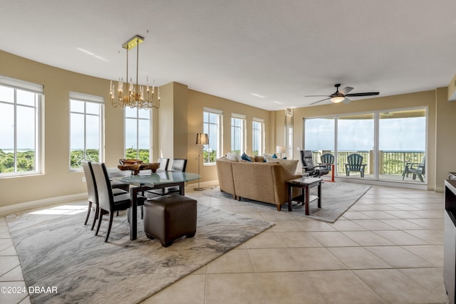 dining area featuring ceiling fan with notable chandelier and light tile patterned floors