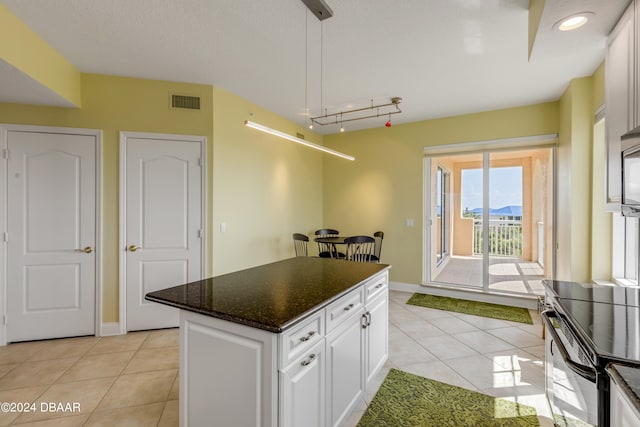 kitchen featuring white cabinetry, pendant lighting, light tile patterned floors, and a kitchen island