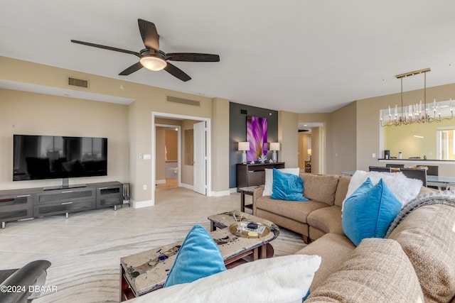 living room with light tile patterned flooring and ceiling fan with notable chandelier