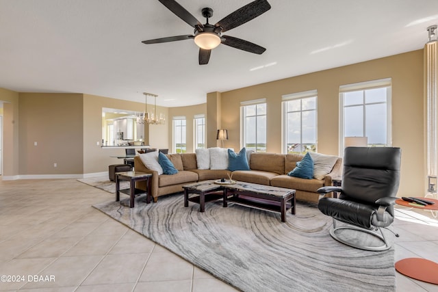 tiled living room featuring ceiling fan with notable chandelier