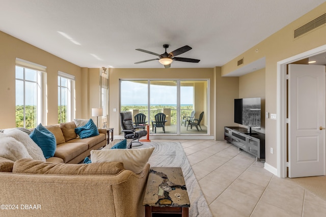 tiled living room with ceiling fan and a textured ceiling