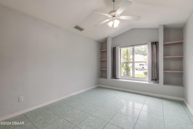 unfurnished room with ceiling fan, built in features, light tile patterned floors, and lofted ceiling