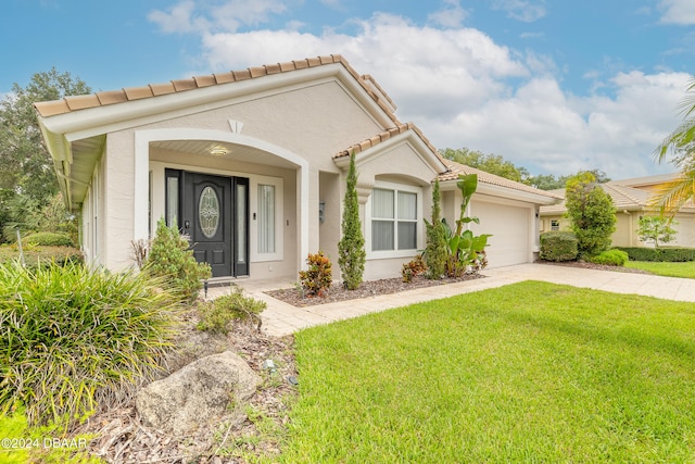 mediterranean / spanish house with a garage and a front yard