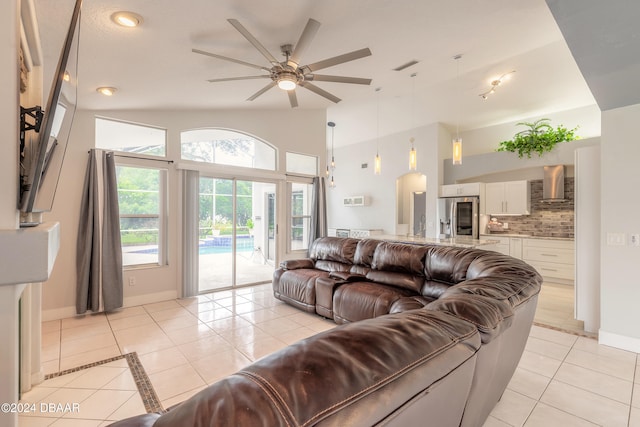 tiled living room with ceiling fan and vaulted ceiling