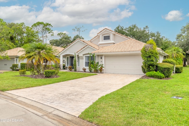 view of front of property with a garage and a front lawn