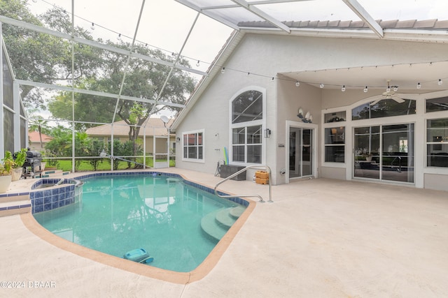 view of swimming pool featuring ceiling fan, glass enclosure, and a patio area