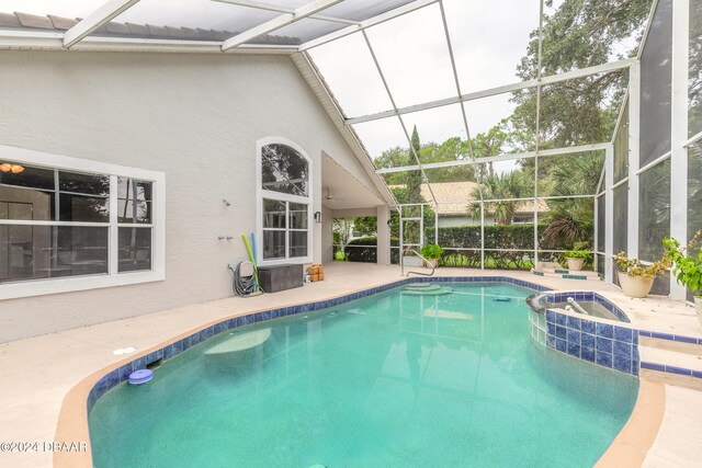 view of swimming pool featuring glass enclosure and a patio area