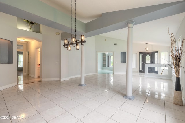 tiled spare room with high vaulted ceiling and an inviting chandelier