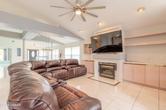 tiled living room with a high end fireplace, ceiling fan with notable chandelier, and vaulted ceiling