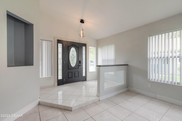 entrance foyer featuring light tile patterned floors and vaulted ceiling