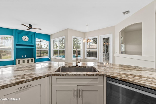 kitchen with white cabinetry, beverage cooler, sink, and hanging light fixtures