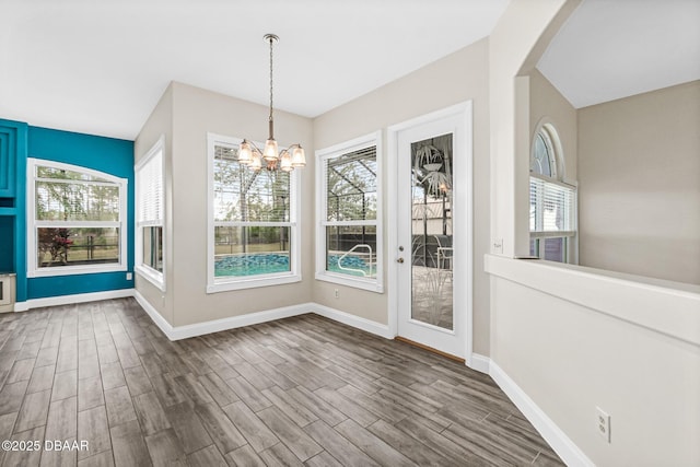 unfurnished dining area with wood-type flooring and a chandelier