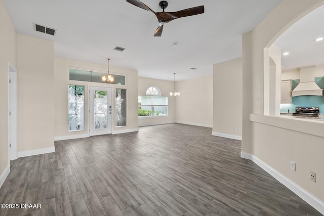 unfurnished living room with hardwood / wood-style floors and ceiling fan with notable chandelier