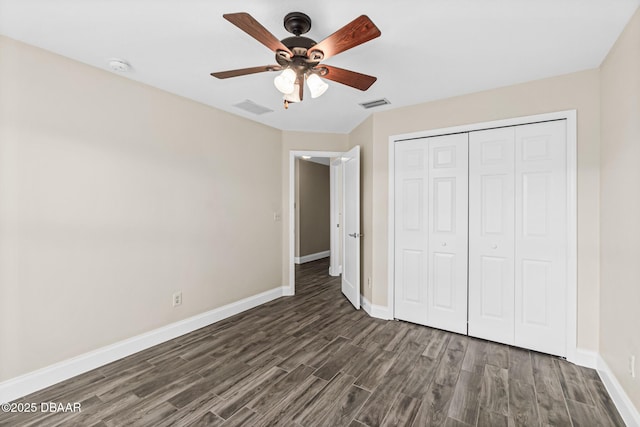 unfurnished bedroom with dark hardwood / wood-style floors, ceiling fan, and a closet