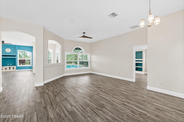 unfurnished living room featuring dark hardwood / wood-style floors and ceiling fan with notable chandelier