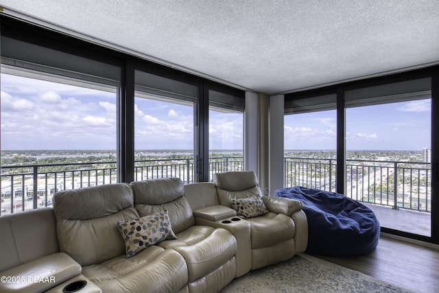 living area featuring wood finished floors, a textured ceiling, and a water view
