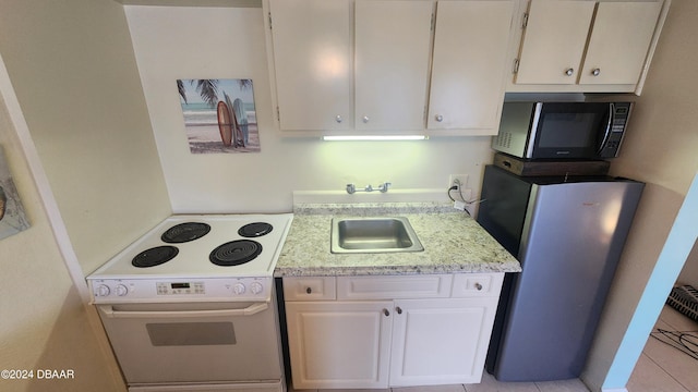 219 S Atlantic Ave Unit 235, Daytona Beach, FL 32118 - kitchen with white electric range oven, freestanding refrigerator, white cabinetry, a sink, and light stone countertops