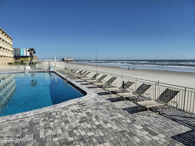 219 S Atlantic Ave Unit 235, Daytona Beach, FL 32118 - community pool featuring view of water and beach, a patio, and fence
