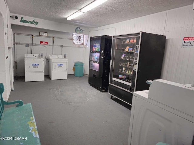 laundry area with independent washer and dryer and a textured ceiling