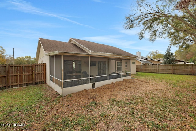 rear view of property featuring a yard, roof with shingles, a fenced backyard, and a sunroom