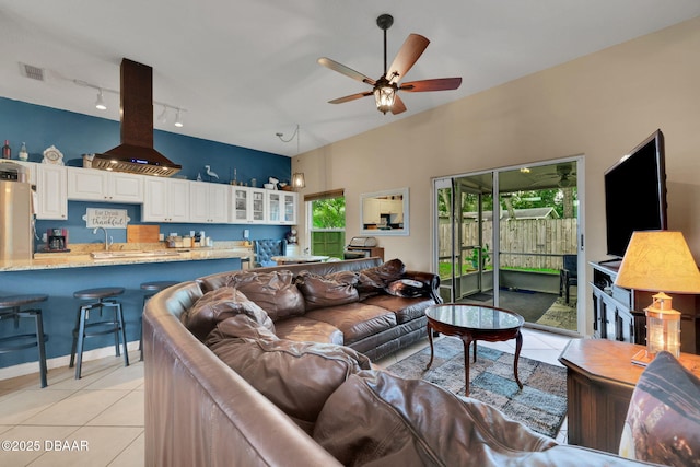 living area with light tile patterned floors, ceiling fan, and visible vents