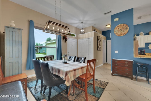 dining area featuring light tile patterned flooring, visible vents, and baseboards