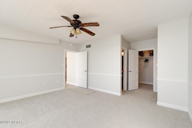 1133 Ocean Shore Blvd Unit 905, Ormond Beach, FL 32176 - unfurnished bedroom with light colored carpet, baseboards, a closet, a ceiling fan, and a walk in closet