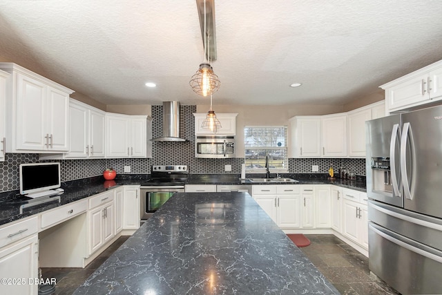 kitchen featuring white cabinetry, stainless steel appliances, and wall chimney exhaust hood