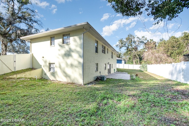 rear view of property featuring a yard and central AC unit