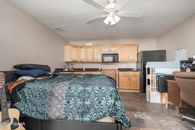 bedroom featuring ceiling fan, black refrigerator, and a textured ceiling